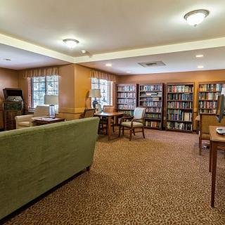 A cozy library reading room with bookshelves and comfortable seating.