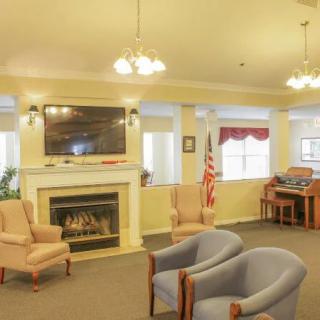 A cozy living room with comfortable seating, a fireplace, and a television.