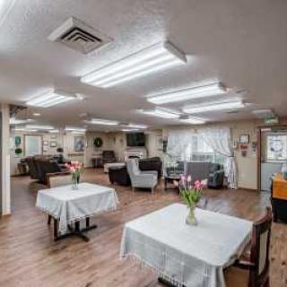 A well-lit dining area with tables set and flowers on display.