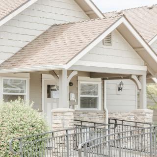A light-colored house with a ramp leading to the front porch.