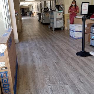 A view of a spacious office hallway with workstations and a person in the background.