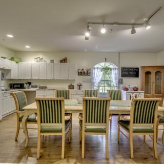 Spacious kitchen with a dining area, featuring a large table and striped chairs.
