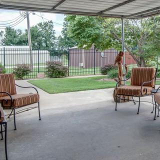 A cozy patio with outdoor chairs overlooking a well-maintained garden.