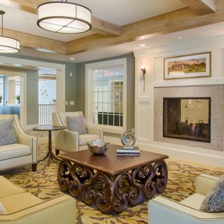 A cozy and elegantly furnished living room featuring a fireplace and comfortable seating.