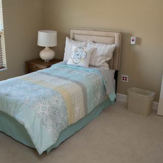 A neatly arranged bedroom with a single bed and minimalist decor.