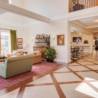 A spacious and modern living room with ample natural light, featuring comfortable furniture and elegant decor.