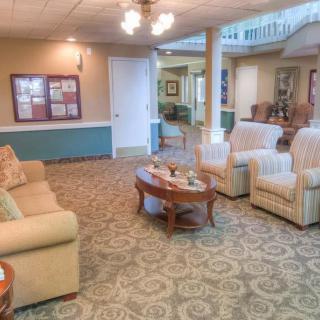 A cozy living room with comfortable seating and a carpeted floor.
