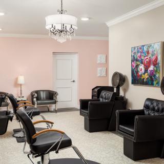 A modern salon interior featuring comfortable chairs, hair dryers, and stylish decor.