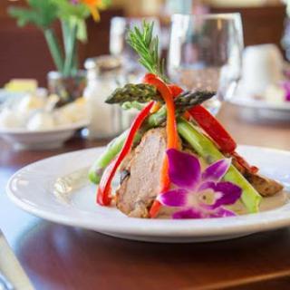 A beautifully presented gourmet dish featuring a medley of vegetables and a floral garnish.