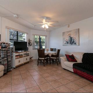 A cozy living room with a dining table, sofa, and television.