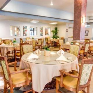 An elegant dining area with neatly arranged tables and chairs, featuring a warm and inviting atmosphere.
