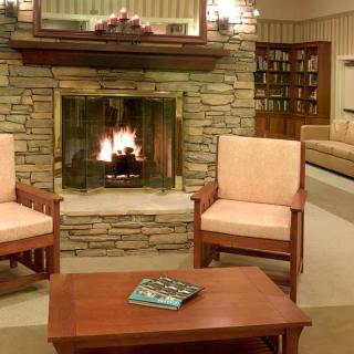 A cozy living room with a stone fireplace and comfortable armchairs.
