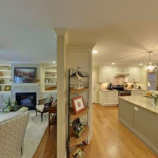 An open floor plan featuring a cozy living room and a modern kitchen with hardwood floors.