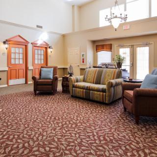 A cozy lobby with comfortable seating arrangements and a decorative chandelier.