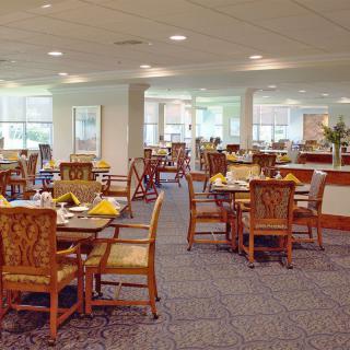 An empty dining room with neatly set tables and chairs.