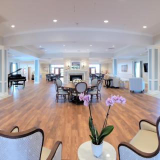 A spacious and elegantly decorated lounge with comfortable seating and a piano.