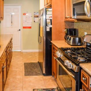A modern kitchen with stainless steel appliances and wooden cabinetry.