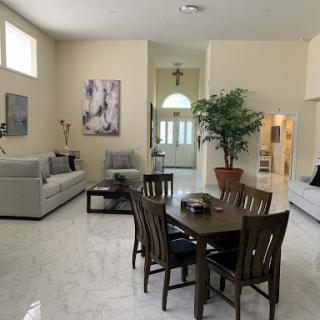 A spacious and elegantly decorated living space featuring modern furniture, a dining table, and an inviting atmosphere.
