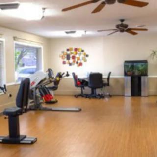 A spacious exercise room featuring fitness equipment and a television.
