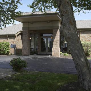 A building entrance with a tree in the foreground.