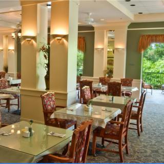 Elegant restaurant interior with neatly arranged tables and chairs, bathed in natural light.