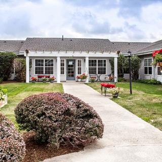A charming house with a well-maintained garden and pathway.