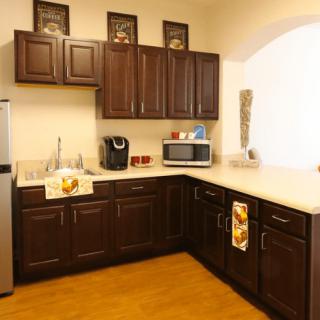 A modern kitchen with dark wooden cabinets and stainless steel appliances.