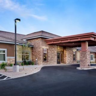 The entrance of a modern healthcare facility with stone accents and a covered driveway.