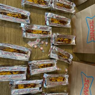A collection of individually wrapped snacks displayed in silver foil on a table.