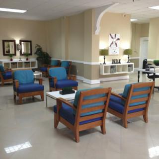 A well-furnished waiting room with chairs and tables arranged neatly.
