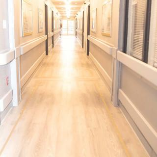 An empty hallway with bright lighting in a healthcare facility.