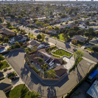 Aerial view of a suburban neighborhood with houses, streets, and greenery.