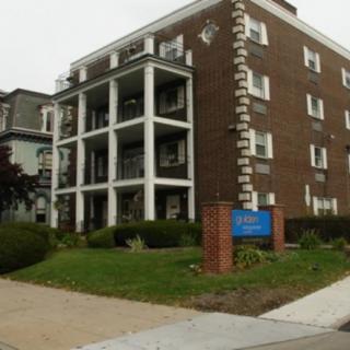 A brick residential apartment building with multiple floors and balconies.