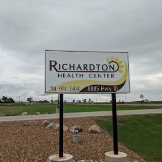 Sign for the Richardton Health Center highlighting its location and services.