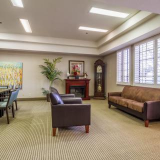 A well-appointed waiting area with comfortable seating and a conference table, featuring elegant interior design elements.