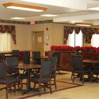 An indoor dining area with multiple tables and chairs, featuring decorative curtains and lighting.