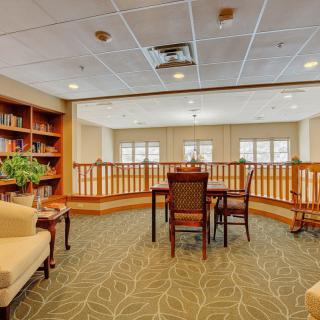 A cozy library space with bookshelves, a table, and chairs.