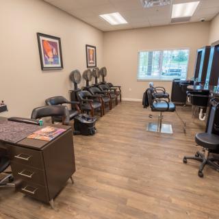An interior view of a modern hair salon with styling chairs and mirrors.