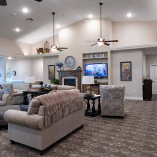 A spacious and elegantly designed living room featuring comfortable sofas, a fireplace, and a large television.