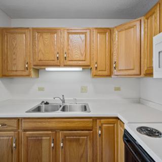 A cozy kitchen featuring wooden cabinets and modern appliances.