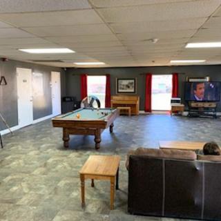 A cozy game room featuring a pool table, couch, and television.