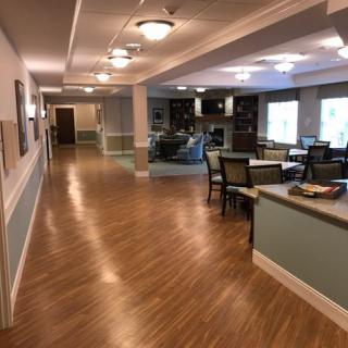 A spacious and well-lit hallway with seating areas and a wooden floor, featuring modern decor.