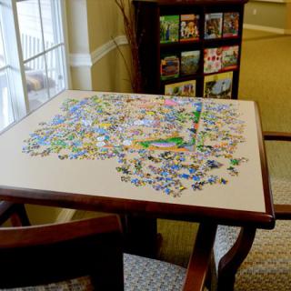 A partially completed jigsaw puzzle on a table in a cozy indoor setting.