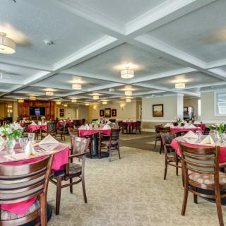 An elegant dining area with neatly arranged tables and chairs, featuring a warm and inviting atmosphere.