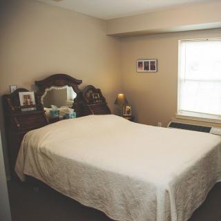 A cozy bedroom with vintage furniture and a decorative mirror.