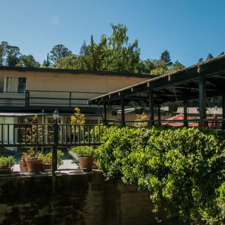 A building with a balcony surrounded by greenery and trees.