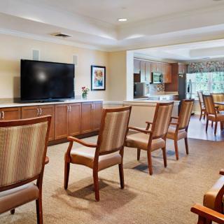 A spacious living room with chairs arranged facing a large television.