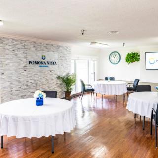 A well-lit conference room with round tables covered in white tablecloths and minimalist decor.