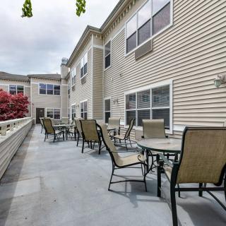 Outdoor patio area with tables and chairs alongside a building.