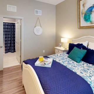 A modern bedroom with a cozy bed, blue bedding, and elegant decor.
